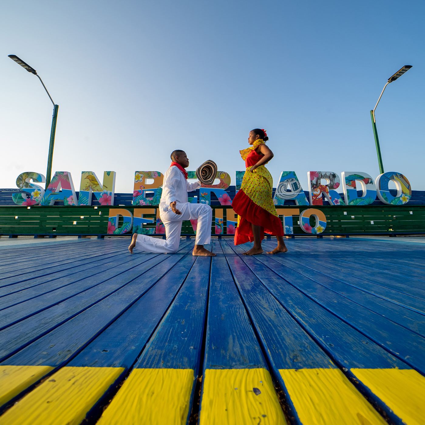 Pareja bailando frente al letrero de San Bernardo del Viento